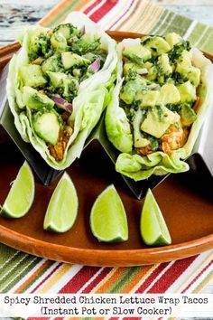 two chicken lettuce wraps with avocado and cilantro on a plate