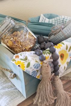 a wooden box filled with lots of food on top of a table next to a towel