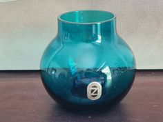 a blue vase sitting on top of a wooden table