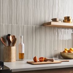 a kitchen counter with utensils and oranges on it next to a cutting board