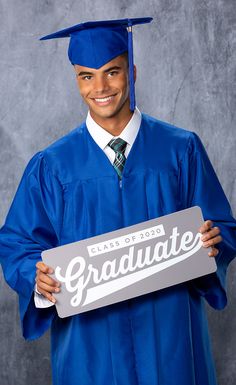 a male in a blue graduation gown and cap holding a sign that says graduate on it