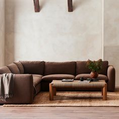 a living room with a brown couch and wooden coffee table