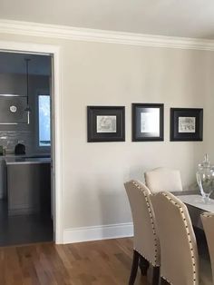 a dining room table with chairs and pictures on the wall