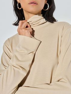 This versatile folded turtleneck top features side slits and a relaxed fit for that effortless cool factor without the fuss. (You might need every color). (This one comes in Champagne.) | Neo Top in Champagne | Ethical Essentials Oversized Turtleneck Top For Work, Solid Color Funnel Neck Top With Relaxed Fit, Oversized Funnel Neck Tops, Versatile Oversized Turtleneck Tops, Relaxed Fit Funnel Neck Top, Solid Color Oversized Top With Funnel Neck, Oversized Funnel Neck Solid Top, Oversized Solid Funnel Neck Top, Everyday Relaxed Fit Tops With Funnel Neck