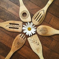 six wooden spoons with designs on them are arranged in the shape of a flower