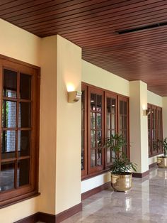 an empty hallway with potted plants and windows