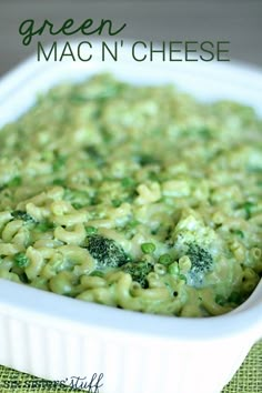 green mac n'cheese in a white dish with broccoli on the side