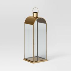 a glass and brass lantern on a white background