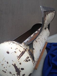 an old white painted shoe sitting on top of a blue blanket next to a gray wall