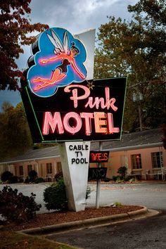 a pink motel sign in front of a building