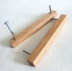 two wooden pegs with nails sticking out of them