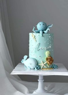 there is a blue cake with an octopus and turtle on the top that says love