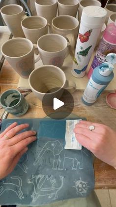 someone is making cups out of clay on a table with other crafting supplies around them