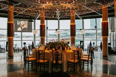 an indoor venue with tables and chairs set up for a formal function in front of large windows