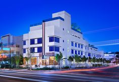 a white building with many windows and lights on it's sides at night time