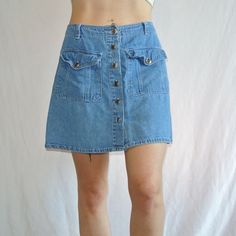 Waist laying flat- 14.5" Length- 16"  Step into the 2000s with this Razzle Dazzle denim skirt from the Y2K era. This vintage skirt features a solid blue color and button closure with pockets, making it perfect for summer or spring. The straight and pencil style is flattering for any body type and the skirt length is short for a flirty look. The Dazzle brand adds a touch of uniqueness to this piece, while the vintage aspect makes it a one-of-a-kind addition to your wardrobe. Whether you're going for a 90s/00s theme or just want to add some retro flair, this skirt is a must-have for any fashion lover. 90s Mini Skirt With Pockets, 90s Denim Skirt With Pockets For Spring, 90s Fitted Denim Skirt With Pockets, 90s Mini Denim Skirt With Pockets, 90s Denim Blue Skirt With Pockets, 90s Denim Skirt With Pockets, 90s Style Mini Denim Skirt With Pockets, Fitted 90s Denim Skirt With Pockets, Vintage Fitted Denim Skirt With Buttons