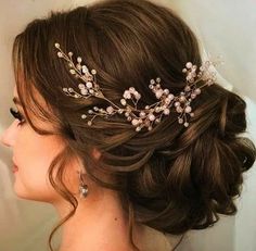 a woman wearing a bridal hair comb with flowers on it's head and pearls in her hair