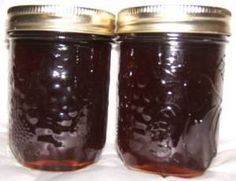 two jars filled with liquid sitting on top of a white cloth covered table next to each other