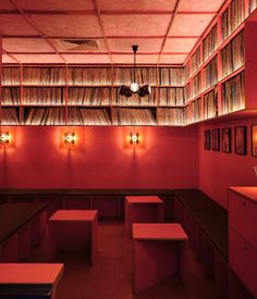 an empty room with red walls and lots of books on the shelves in front of it