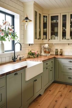 a kitchen with green cabinets and wooden floors