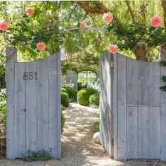 two wooden gates with flowers hanging over them