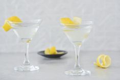 two martini glasses with lemon wedges on the rim