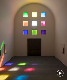 an empty room with several different colored lights coming through the window and onto the floor