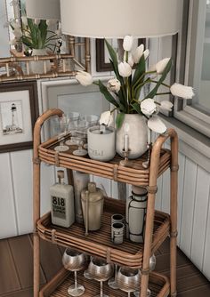 a wicker bar cart with flowers and glasses on it