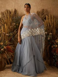 Dusty blue layered georgette lehenga with an attached hand embellished mother of pearl drape, paired with a hand embellished floral mother of pearl and zardozi cropped blouse with a tie back.From Shloka Khialani' s Serendipity collection.DELIVERY TIMEPlease allow 6-8 weeks for your outfit to arrive.FABRIC DETAILSGeorgette, Net, CrepeProfessional cleaning only. Drape Lehenga, Layered Lehenga, Lehenga Online Shopping, Sari Lehenga, Georgette Lehenga, Bridal Lehenga Collection, Lehenga Online, Choli Designs, Bridal Lehenga Choli