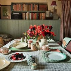 a dining room table with plates and flowers on it