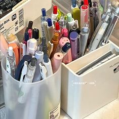 an assortment of pens, markers and pencils in a container on a counter top