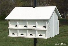 a white bird house with several holes in the roof