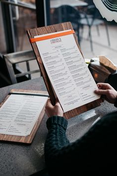 a person sitting at a table with a menu in front of them