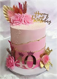 a pink birthday cake decorated with feathers and flowers