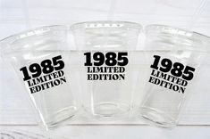 three clear cups with black lettering on them