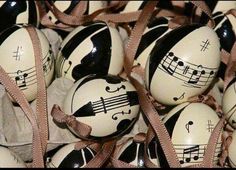 some black and white decorated eggs with musical notes painted on them are wrapped in brown ribbon