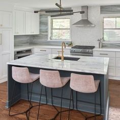 a kitchen with marble counter tops and bar stools