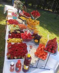 a table full of different types of fruits and vegetables on it's sides, including strawberries