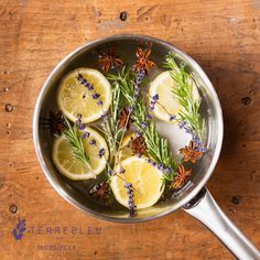 lemons, rosemary, and star anise in a pan on a wooden table