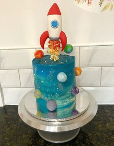 a space themed birthday cake with a rocket on top