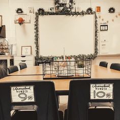 a table with chairs and a whiteboard in the back drop off wall behind it