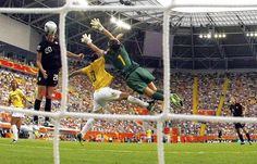 a soccer goalie jumps up to block the ball