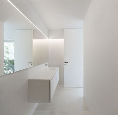 an empty bathroom with white walls and cabinets