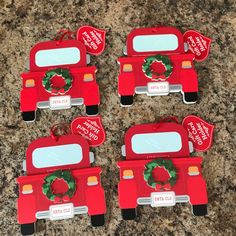 four red firetruck shaped magnets with christmas wreath on the front and back