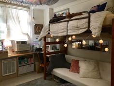 a bunk bed with lights hanging from it's sides in a dorm style room