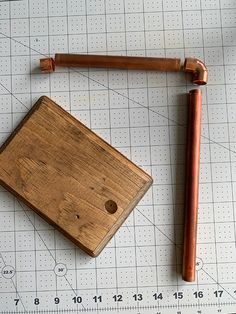 a piece of wood sitting on top of a cutting board next to a wooden ruler