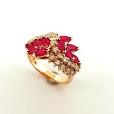 "A dazzling Ruby and Diamond Ring.  This glowing vivid red natural earth mined ruby and sparkly diamond ring is superb.  It is crafted in solid 14K yellow gold and weighs approximately 6.1 grams.  There are a full 2 carats of 20 point BRIGHT red marquise cut exceptional gem quality rubies set into this ring.  The rubies are arranged along the shoulders on each side and rise to join in the middle. A cascade of diamonds falls between the beautiful ruby laurel wreath clusters.  In total there is 1. Marquise Red Diamond Ring, Red Marquise Diamond Ring Fine Jewelry, Red Cluster Ring With Brilliant Cut For Promise, Red Marquise Brilliant Cut Ring, Red Marquise Ruby Ring With Prong Setting, Red Brilliant Cut Cluster Ring For Promise, Cluster Ruby Ring With Diamonds, Red Cluster Rings With Brilliant Cut, Red Cluster Diamond Ring With Brilliant Cut