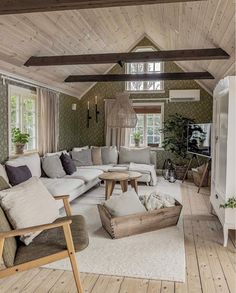 a living room filled with lots of furniture and wooden flooring next to a window