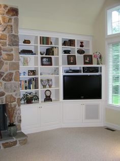 a living room filled with furniture and a flat screen tv mounted on a wall next to a fire place