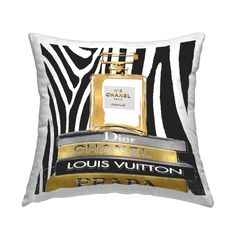 a black and white pillow with a bottle of chanel on the front in gold foil